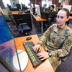 Veteran woman on computer on campus. 