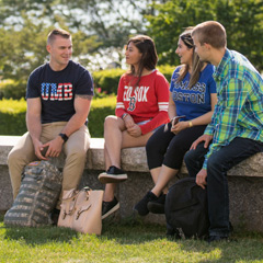 Four students sitting outside on campus